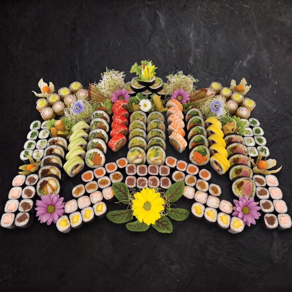 Zestaw bal Nova Sushi — 150 kawałków sushi ułożonych w wachlarz: futomaki, california, hosomaki i nigiri z kwiatami jadalnymi.